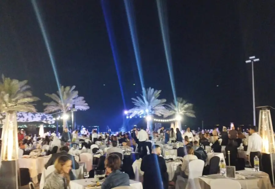 Outdoor gala dinner under beam lighting