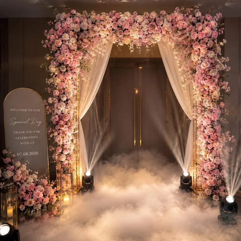 A floral wedding entrance arch with low haze and uplighting